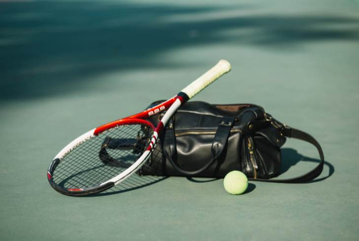 Black leather tennis bag with racket and ball
